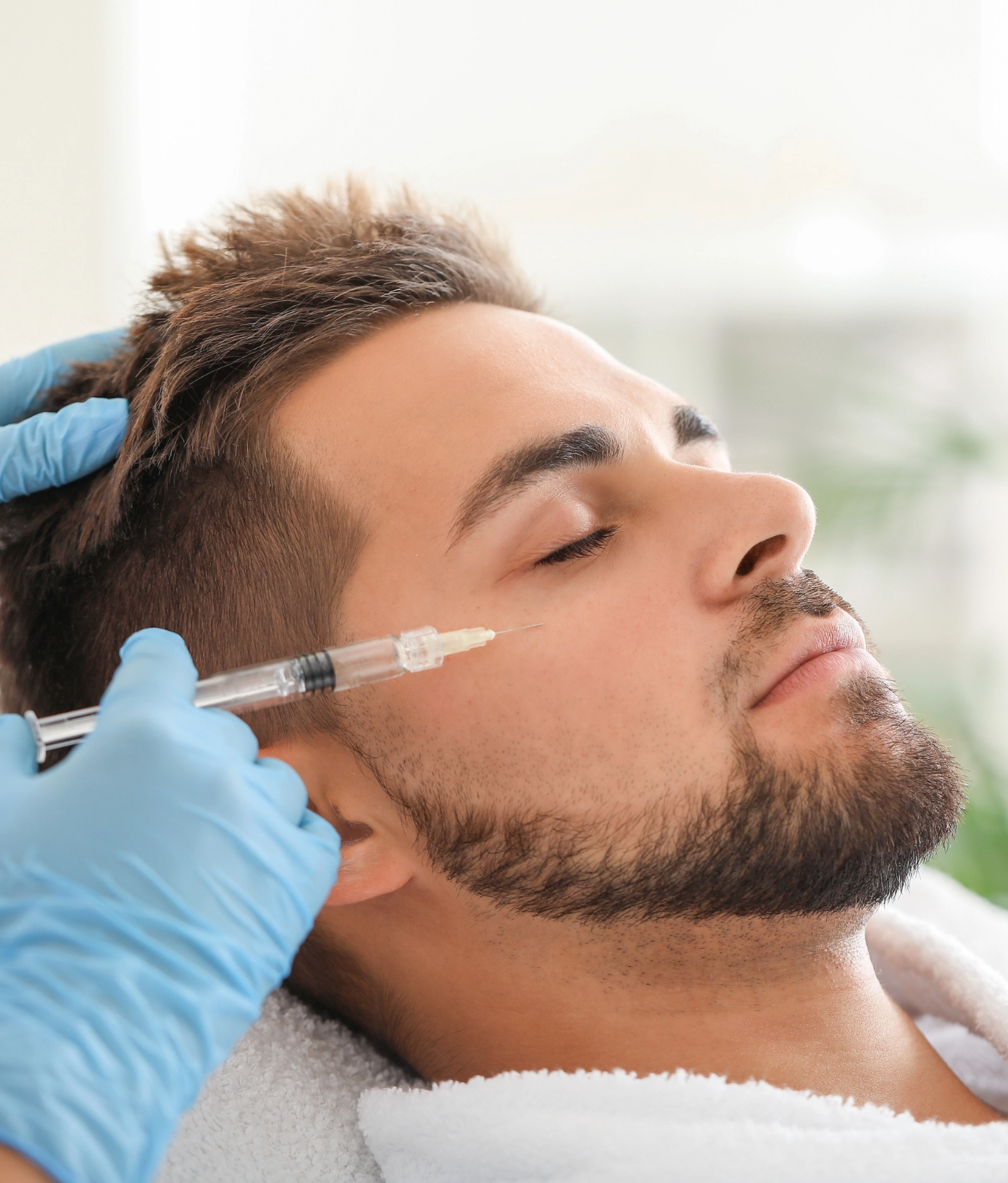 A young man receives a Botox injection from a professional injector.