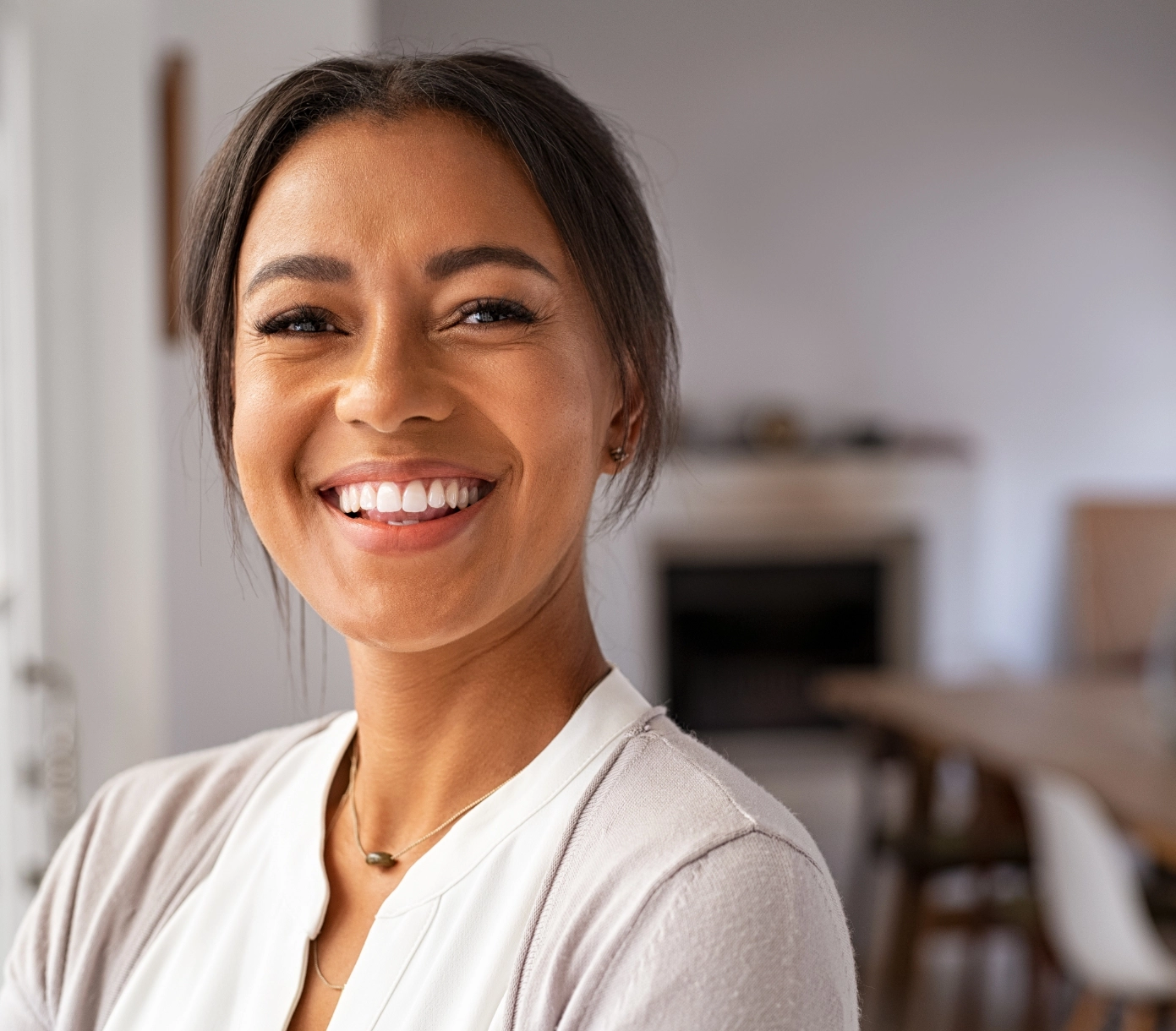 A young woman smiles at the camera after receiving Botox.