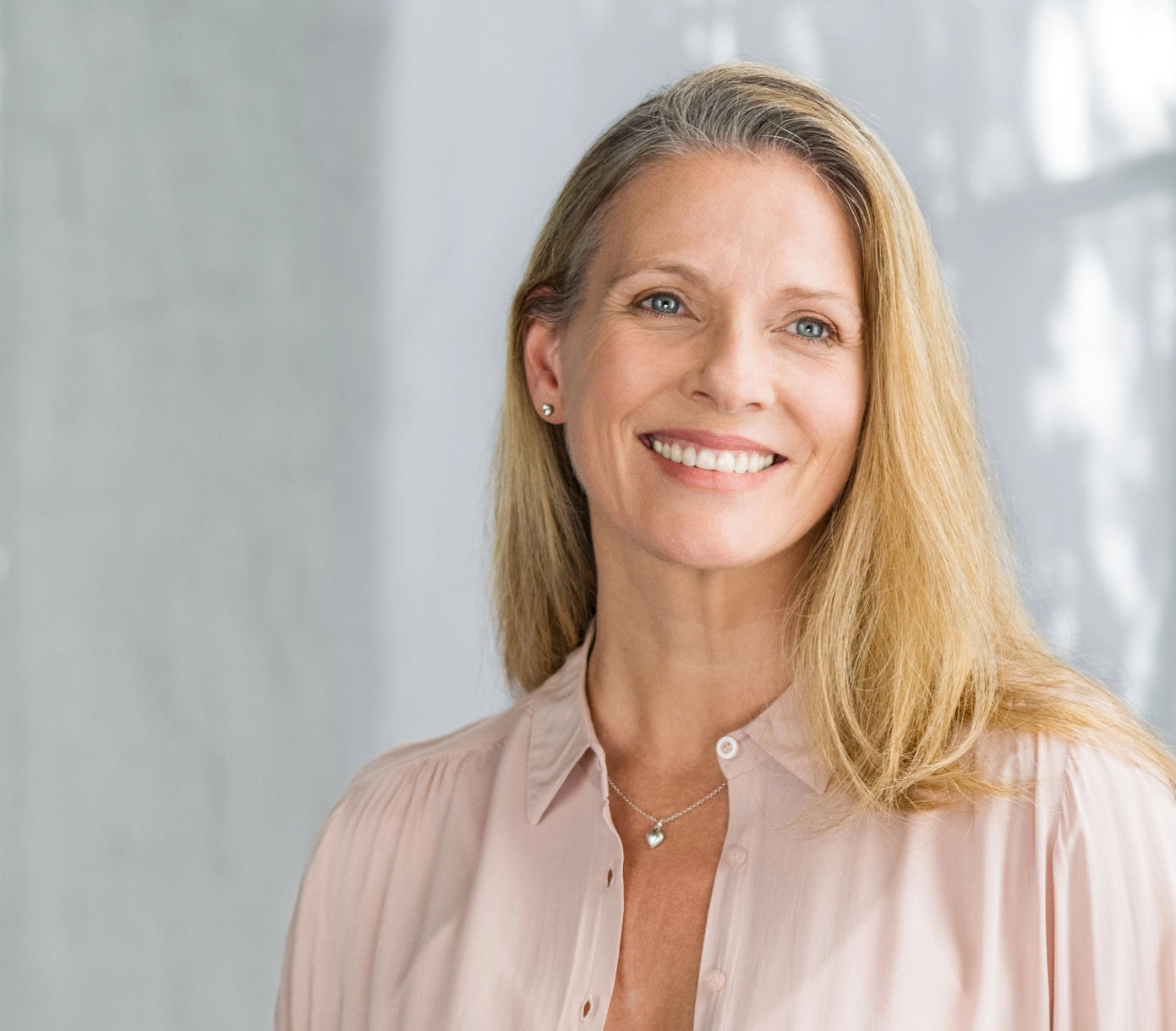 A middle-aged woman smiles after receiving JUVÉDERM®.